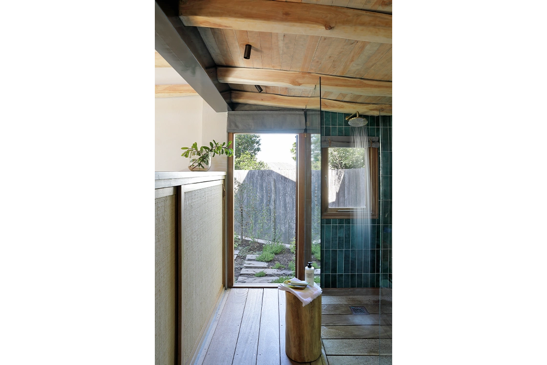 Perfect Hideaways property for sale: A bathroom with green-tiled walls, a rain shower, and a wooden stool, offering a seamless blend of indoor and outdoor elements through large windows. Yellowwood Cottage, Churchhaven.