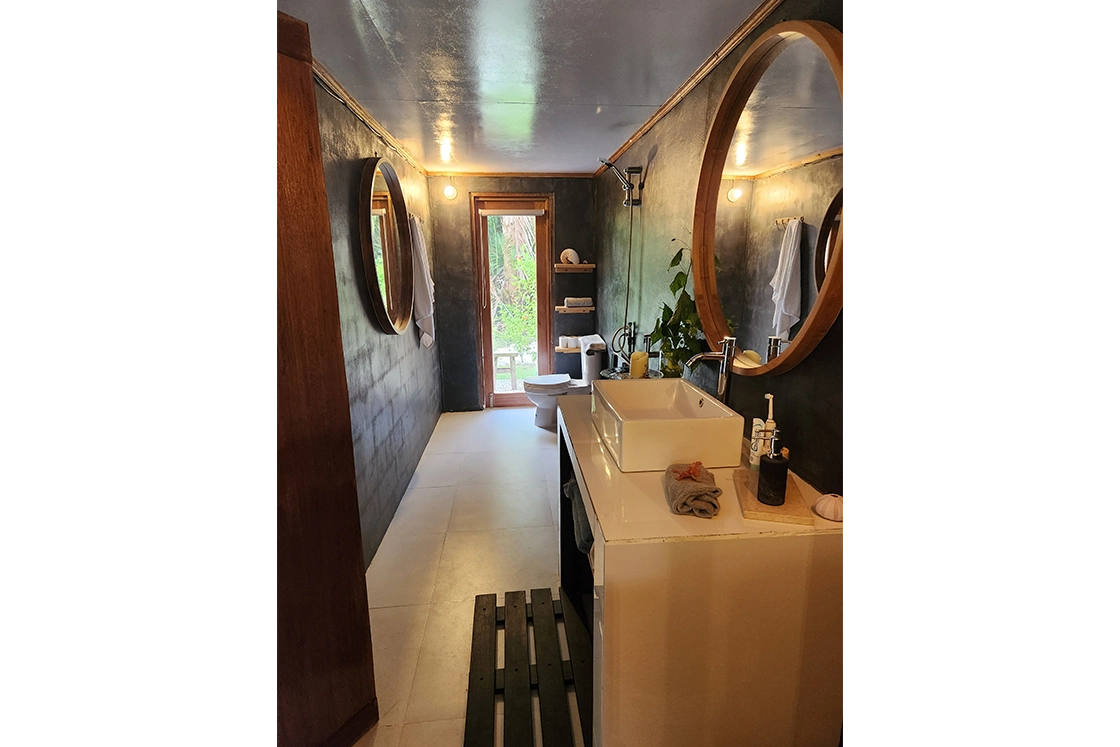 Perfect Hideaways real estate property: A bathroom featuring a basin unit, circular mirrors, and a shower. Leleu Boutique Beach Villas, Mentawai.