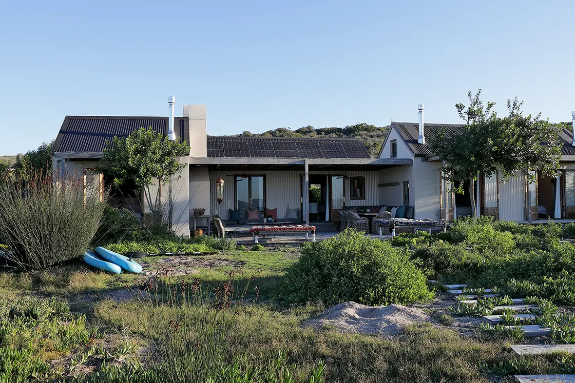Perfect Hideaways property for sale: A wide shot of the cottage surrounded by greenery, with inviting outdoor seating areas and a tranquil atmosphere. Yellowwood Cottage, Churchhaven.