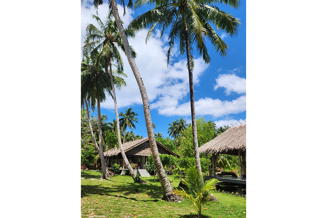 Perfect Hideaways real estate property: A couch with a decorative cushion on a patio, with beachfront views of a private beach. Leleu Boutique Beach Villas, Mentawai.